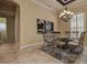 Formal dining room with chandelier, modern artwork, and views of shuttered windows at 12713 Grand Traverse Dr, Dade City, FL 33525