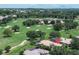Aerial view of a golf home surrounded by lush greenery and mature trees at 12713 Grand Traverse Dr, Dade City, FL 33525