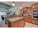 Open-concept kitchen with island, stainless appliances, tile backsplash and adjacent casual living area at 12713 Grand Traverse Dr, Dade City, FL 33525