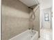 Tiled bathroom features a shower with a white tub and tile surround at 13991 Coronado Dr, Spring Hill, FL 34609