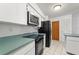 Compact kitchen featuring tile flooring and modern appliances at 13991 Coronado Dr, Spring Hill, FL 34609