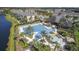 Aerial view of community pool, clubhouse and nearby apartment buildings with lake and palm trees at 14617 Galt Lake Dr, Tampa, FL 33626