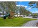 can enjoy a wooden swing set with a slide in this private backyard with mature landscaping and lake views at 14617 Galt Lake Dr, Tampa, FL 33626