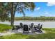 Inviting backyard patio with lake view, featuring a fire pit and comfortable Adirondack chairs at 14617 Galt Lake Dr, Tampa, FL 33626