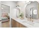 Bathroom with double sinks, gold fixtures, and a view into a bedroom at 14617 Galt Lake Dr, Tampa, FL 33626