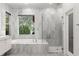 Bright bathroom showcasing marble features, a soaking tub, and glass-enclosed shower at 14617 Galt Lake Dr, Tampa, FL 33626