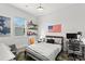 Modern bedroom with American flag, grey bedding, and a desk area at 14617 Galt Lake Dr, Tampa, FL 33626