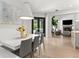 Bright dining room open to living room featuring modern light fixture and large windows at 14617 Galt Lake Dr, Tampa, FL 33626