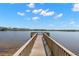 Lakeside wooden community dock leading out to tranquil waters under a partly cloudy sky at 14617 Galt Lake Dr, Tampa, FL 33626