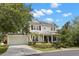 A two-story home with a manicured lawn, lush plants and bushes, and a driveway leading to an attached garage at 14617 Galt Lake Dr, Tampa, FL 33626