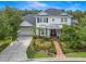 A charming two-story home with white exterior, a well-manicured lawn, brick path, and attached garage at 14617 Galt Lake Dr, Tampa, FL 33626