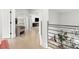 Hallway with light wood floors, modern railing, and an arched mirror creating an open and inviting space at 14617 Galt Lake Dr, Tampa, FL 33626