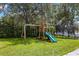 A wooden swing set with a slide and jungle gym provide a safe and fun playground in the backyard at 14617 Galt Lake Dr, Tampa, FL 33626