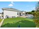 Lush artificial lawn in backyard with brick patio, perfect for recreation and relaxation at 15415 Otto Rd, Tampa, FL 33624