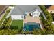 Aerial shot of the pool and backyard including turf, patio and a lounge area, all enclosed by a white fence at 15415 Otto Rd, Tampa, FL 33624