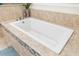 Bright bathroom featuring a simple white bathtub with light-colored tile surround at 15415 Otto Rd, Tampa, FL 33624