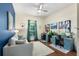 Well-lit bedroom with a blue accent wall, two desks, and a sofa at 15415 Otto Rd, Tampa, FL 33624