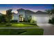 Beautiful home exterior featuring well manicured landscaping, double front doors, and a white two car garage at 15415 Otto Rd, Tampa, FL 33624
