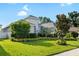 Beautifully landscaped front yard with lush lawn, manicured shrubs and a freshly painted home at 15415 Otto Rd, Tampa, FL 33624
