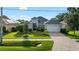 Charming single-story home featuring a well-manicured lawn and a brick-paved driveway leading to a two-car garage at 15415 Otto Rd, Tampa, FL 33624