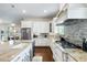 Spacious kitchen with custom cabinets, granite counters, tile backsplash, and stainless steel appliances at 15415 Otto Rd, Tampa, FL 33624