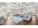 Spacious living room featuring hardwood floors, coffered ceiling, and a view of the kitchen and backyard at 15415 Otto Rd, Tampa, FL 33624