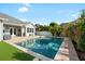 Gorgeous pool and patio area is surrounded by lush tropical plants, creating a private backyard oasis at 15415 Otto Rd, Tampa, FL 33624