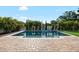 Backyard showcasing a sparkling in-ground pool with lush landscaping and brick pavers at 15415 Otto Rd, Tampa, FL 33624