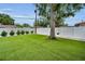 Spacious backyard with lush artificial turf, mature tree with a swing, and a white privacy fence at 1557 77Th N Ave, St Petersburg, FL 33702