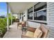 Relaxing front porch features wicker chairs, a small table, and view of the landscaped front yard at 1557 77Th N Ave, St Petersburg, FL 33702