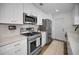 Modern kitchen featuring stainless steel appliances, white cabinets, and stylish gold hardware at 1557 77Th N Ave, St Petersburg, FL 33702