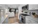 Bright kitchen boasts stainless steel appliances and white cabinetry with gold hardware accents at 1557 77Th N Ave, St Petersburg, FL 33702