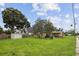 A single-Gathering home set on a sprawling lawn, showcasing classic design and mature trees under a clear sky in a quiet neighborhood at 1560 Connecticut Ne Ave, St Petersburg, FL 33703