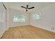 Bright bedroom with wood-look floors, ceiling fan, and natural light at 1723 Cypress Ave, Belleair, FL 33756