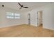 Bright bedroom with wood-look floors, ceiling fan, and window view at 1723 Cypress Ave, Belleair, FL 33756