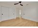Bright bedroom features wood flooring, white walls, closet, and a modern ceiling fan at 1723 Cypress Ave, Belleair, FL 33756