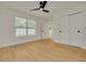 Bright bedroom with wood-look floors, ceiling fan, and a sliding closet at 1723 Cypress Ave, Belleair, FL 33756