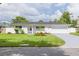Charming single-story home featuring a manicured front lawn, landscaping, and a two-car garage at 1723 Cypress Ave, Belleair, FL 33756