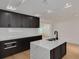 Bright kitchen featuring quartz countertops, dark cabinets and a modern island at 1723 Cypress Ave, Belleair, FL 33756