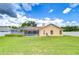 Picture of a large, grassy backyard with a white vinyl fence and a view of the house and pool area at 17302 Stetson Ln, Odessa, FL 33556