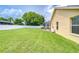 Spacious backyard with a lush green lawn, white fence, and the side of the house visible at 17302 Stetson Ln, Odessa, FL 33556