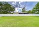Expansive backyard featuring a manicured lawn, privacy fence, and mature trees, providing a serene outdoor space at 17302 Stetson Ln, Odessa, FL 33556