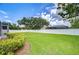 Expansive backyard featuring lush green lawn, landscaping, and a pristine white privacy fence at 17302 Stetson Ln, Odessa, FL 33556