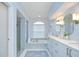 Luxurious bathroom featuring a soaking tub, glass-enclosed shower, and dual vanities at 17302 Stetson Ln, Odessa, FL 33556
