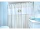 Bathroom with a charming coastal-themed shower curtain and bright natural light from a window at 17302 Stetson Ln, Odessa, FL 33556