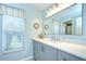 Well-lit bathroom with a spacious vanity, a large mirror, decorative accents, and ample natural light at 17302 Stetson Ln, Odessa, FL 33556