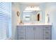 Well-lit bathroom with a modern vanity, a large mirror, and bright natural light from the window at 17302 Stetson Ln, Odessa, FL 33556