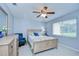 Bedroom with a wooden bed frame, neutral walls, a ceiling fan, and a window offering natural light at 17302 Stetson Ln, Odessa, FL 33556