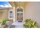 Elegant entryway with double doors, decorative wreaths, sidelight windows, and manicured landscaping at 17302 Stetson Ln, Odessa, FL 33556