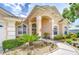 Stunning exterior view of a home with manicured landscaping, a walkway, and an arched entryway at 17302 Stetson Ln, Odessa, FL 33556
